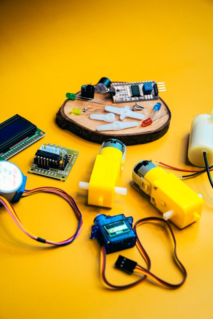 services-04 Assorted robotics kit components displayed against a bright yellow background, highlighting innovation and technology.