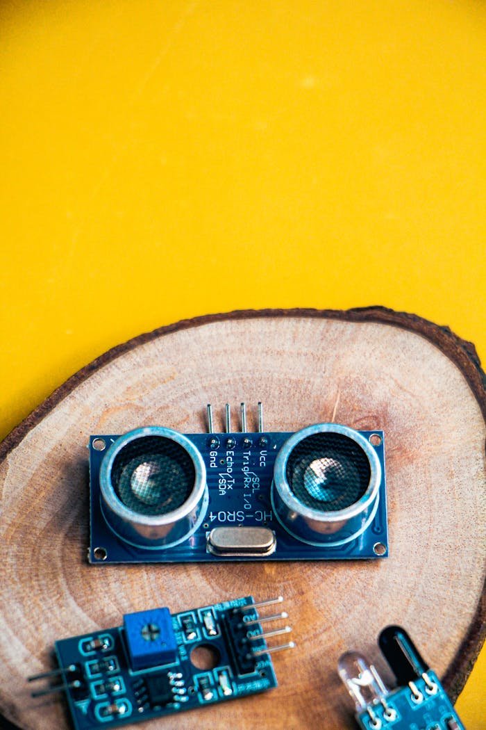 services-01 Close-up of electronic modules on a wooden slice against a vibrant yellow background.